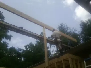 Carpenter setting a ridge beam over a new addition frame — Ice Dam Removal by Roofing Brothers in Matlock